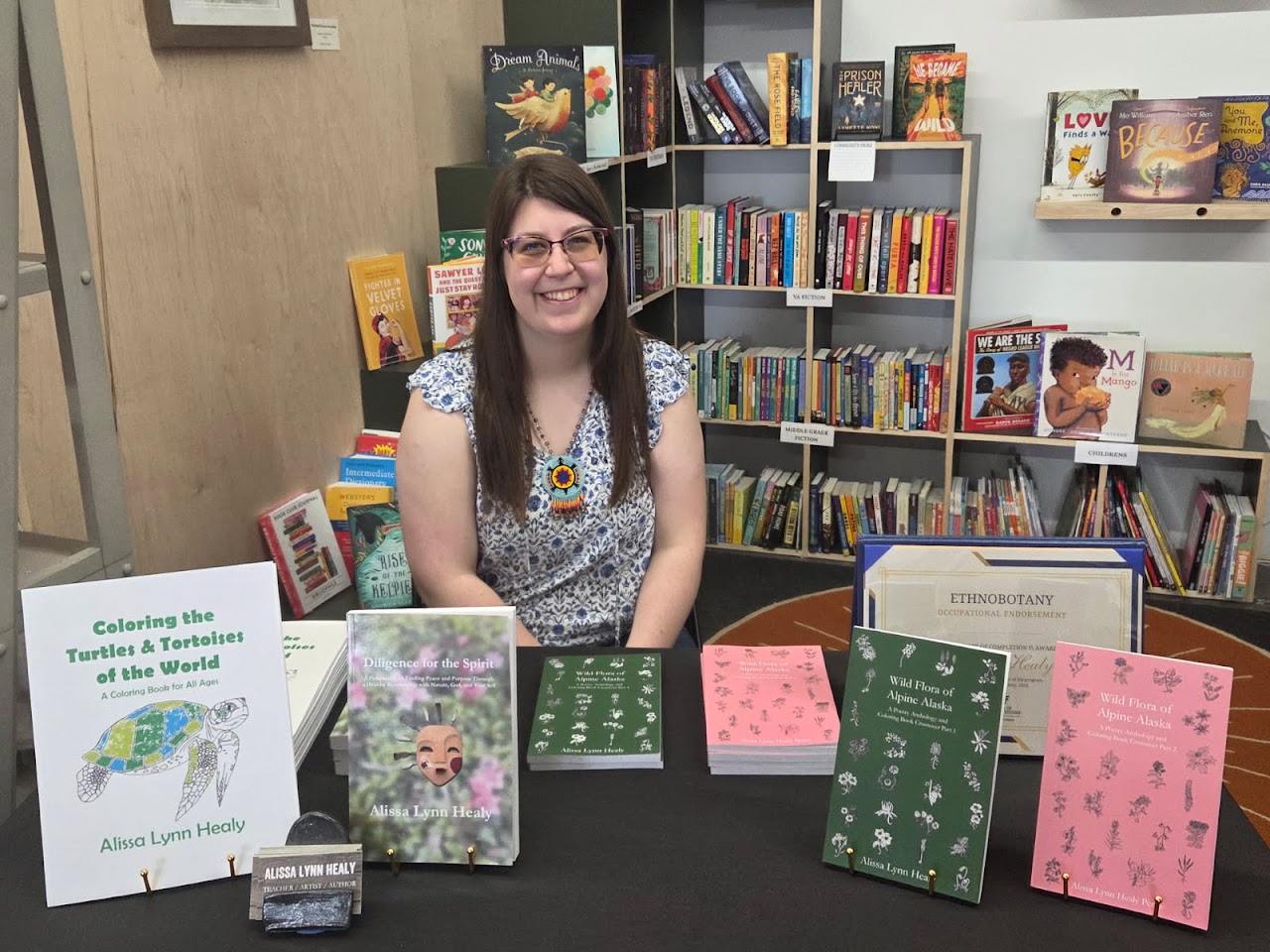 Young woman sitting behind table with books